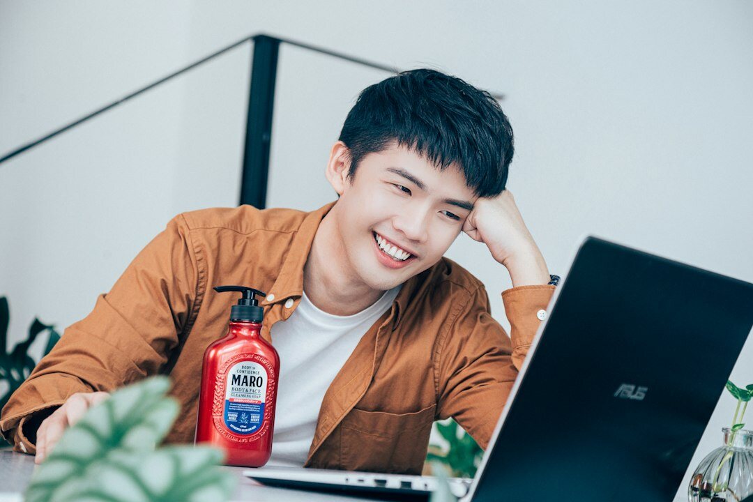 Young man smiling while using a laptop